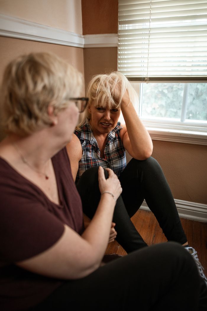 Two women engaged in a comforting moment, highlighting support and empathy.